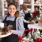 Lächelnde Verkäuferin mit Weihnachtsgeste