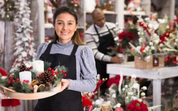 Lächelnde Verkäuferin mit Weihnachtsgeste