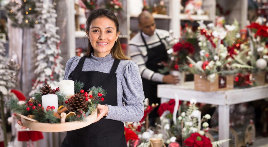 Lächelnde Verkäuferin mit Weihnachtsgeste
