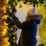 Frau dekoriert ein Verkaufsfenster weihnachtlich